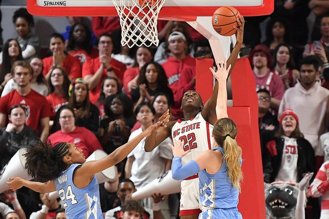 N.C. State's Saniya Rivers (22) makes the reverse layup against North Carolina's Indya Nivar (24) and Alyssa Ustby (1) during the first half. The N.C. State Wolfpack and the North Carolina Tar Heels met in a regular-season game in Raleigh, N.C., on Feb. 1, 2024.