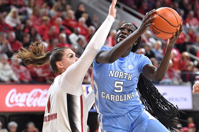 North Carolina's Maria Gakdeng (5) shoots against N.C State's River Baldwin during the fist half. The N.C. State Wolfpack and the North Carolina Tar Heels met in a regular-season game in Raleigh, N.C., on Feb. 1, 2024.