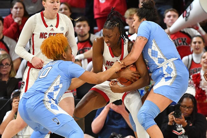 NC State's Saniya Rivers (22) defends the ball from North Carolina's Alexandra Zelaya (0) and Reniya Kelly (10) during the first half. The N.C. State Wolfpack and the North Carolina Tar Heels met in a regular-season game in Raleigh, N.C., on Feb. 1, 2024.