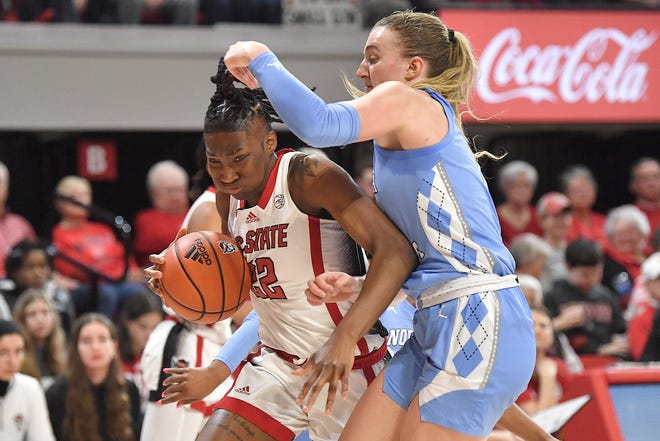 N.C. State's Saniya Rivers (22) drives to the basket against North Carolina's Alyssa Ustby (1) in the second half. The N.C. State Wolfpack and the North Carolina Tar Heels met in a regular-season game in Raleigh, N.C., on Feb. 1, 2024.