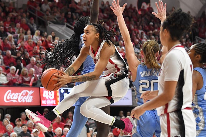 N.C State's Aziaha James' (10) layup splits the defense from North Carolina's Lexi Donarski (20) and Maria Gakdeng (5) during the second half. The N.C. State Wolfpack and the North Carolina Tar Heels met in a regular-season game in Raleigh, N.C., on Feb. 1, 2024.