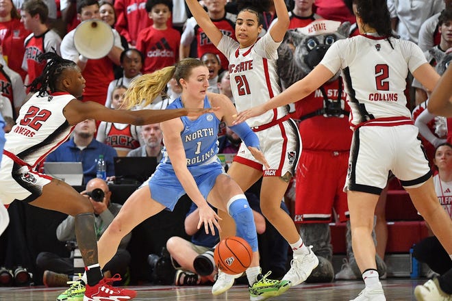 N.C State's Saniya Rivers (21) Mimi Collins (2) and Madison Hayes (21) defend North Carolina's Alyssa Ustby in the fourth quarter. The N.C. State Wolfpack and the North Carolina Tar Heels met in a regular-season game in Raleigh, N.C., on Feb. 1, 2024.