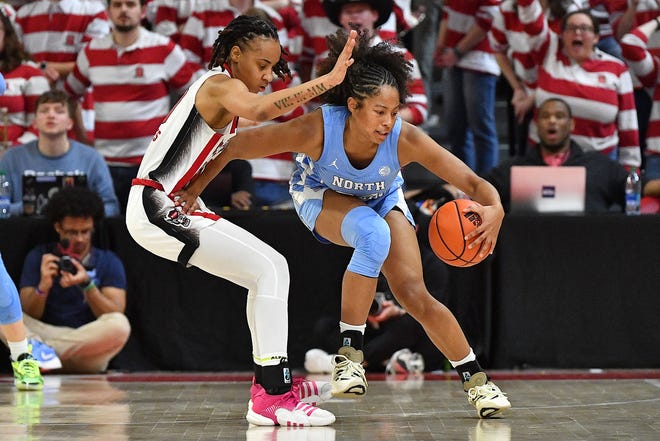 North Carolina's Indya Nivar (24) spins against the defense from N.C State's Aziaha James late in the fourth quarter. The N.C. State Wolfpack and the North Carolina Tar Heels met in a regular-season game in Raleigh, N.C., on Feb. 1, 2024.