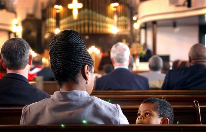 Three year old L.J. Harrington looks up at his mother, Valencia, during church service Sunday morning at the Evans Metropolitan AME Zion Church on North Cool Springs Street in 2006.