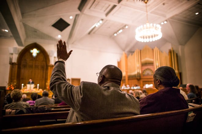 Bishop Samuel Monroe, Sr. raises his hand in agreement as Evans Metropolitan A.M.E. Zion Church pastor Rev. Corey D. Little preaches to the congregation at the community Thanksgiving service at Hay Street United Methodist Church on Nov. 23, 2014.