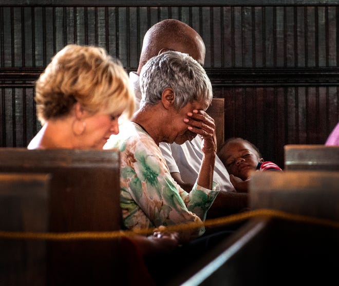 AnnaLisa Johannessen Locke, left, prays with Shirley and Lester Bussey while Mr. Bussey is holds his great grandson, D.J. Fryar during the prayer service at Evans Metropolitan AME Zion Church, 301 N. Cool Spring Street in Fayetteville, Friday June 19, 2015. The public was invited for a prayer and solidarity service, In response to the church shooting in Charleston, S.C.