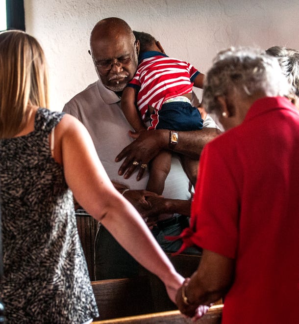 Lester Bussey holds his great grand son, D.J. Fryar,16 months old during the prayer service at Evans Metropolitan AME Zion Church, 301 N. Cool Spring Street in Fayetteville,Friday June 19, 2015 the public was invited for a prayer and solidarity service. In response to the church shooting in Charleston, S.C.