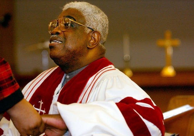 Pastor Aaron Johnson greets church goers at the Good Friday service at Mount Sinai Baptist Church on March 29, 2002.