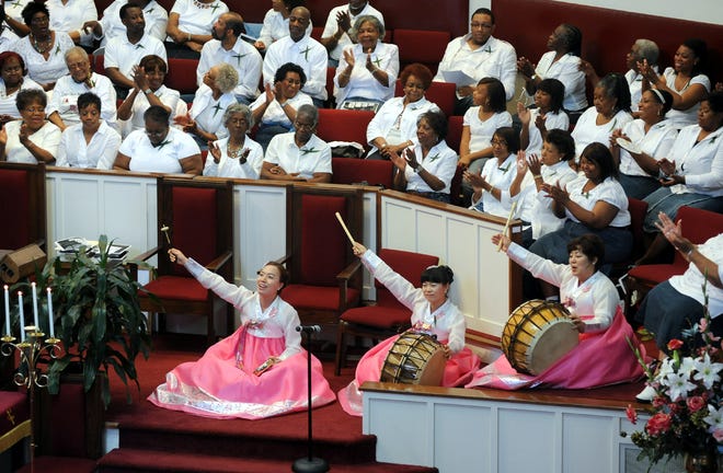 The Lewis Chapel Missionary Baptist Church choir applauds the Korean musicians that provided music for Lewis Chapel's 100th anniversary and homecoming service Sunday, April 17, 2011.