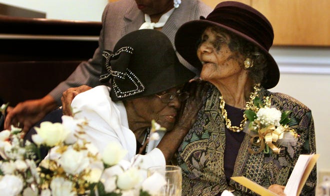Carrie Mosley and Estelle Wells share a moment before their 100th Birthday Celebration Luncheon Sunday afternoon, Oct. 11, 2009, at the Lewis Chapel Missionary Baptist Church.
