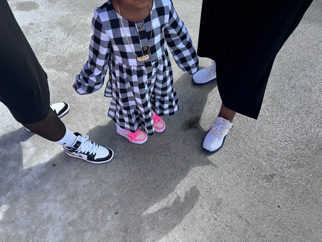 Helena Rucks, 41, Brooklyn Lewis, 3, and Mary Rucks, 56, showing off their sneakers at the 3rd annual It's a Family Affair Sneaker Ball event at Segra Stadium, Mar. 2, 2024.