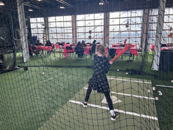 10-year-old Macy Mercsak standing at the plate in a batting cage at the 3rd annual It's a Family Affair Sneaker Ball even at Segra Stadium, Mar. 2, 2024.