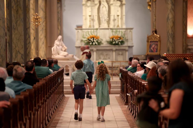 March 16, 2024: Children walk down the aisle during the St. Patrick's Day Mass on Saturday, March 16, 2024 at the Cathedral Basilica of St. John The Baptist in Savannah, Georgia.