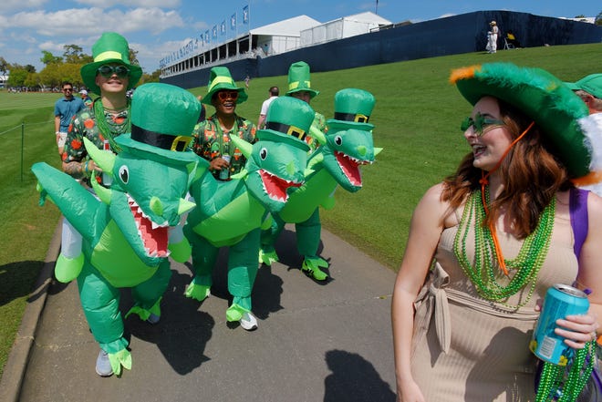 March 17, 2024 : Austyn Scruggs, Alex Sutton and Josh Taylor, all sailors from NAS Jacksonville make their way down the 18th hole fairway in their St. Patrick's Day dragon costumes during the fourth and final round of The Players Championship PGA golf tournament at TPC Sawgrass in Ponte Vedra Beach, Fla.
