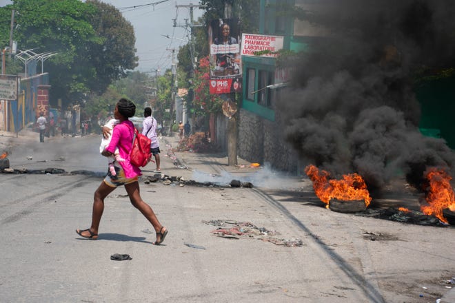 March 20, 2024: A woman carrying a child runs from the area after gunshots were heard in Port-au-Prince, Haiti. Negotiations to form a transitional council to govern Haiti advanced on March 20, as the United States airlifted more citizens to safety from gang violence that has plunged the impoverished country into chaos.