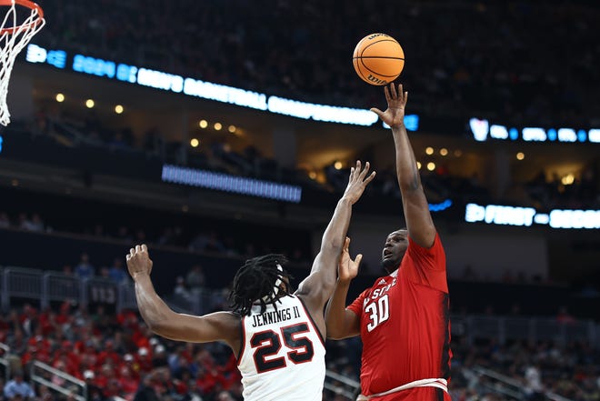 NC State's DJ Burns Jr. shoots against Texas Tech's Robert Jennings during the first half in the first round of the NCAA Men's Basketball Tournament, Thursday, March 21, 2024, at PPG PAINTS Arena in Pittsburgh, Pennsylvania.