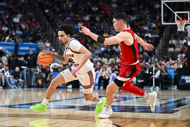 Texas Tech's Pop Isaacs drives against NC State's Michael O'Connell during the first half in the first round of the NCAA Men's Basketball Tournament, Thursday, March 21, 2024, at PPG PAINTS Arena in Pittsburgh, Pennsylvania.