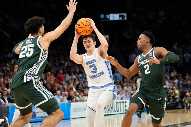 North Carolina Tar Heels guard Cormac Ryan (3) drives between Michigan State Spartans forward Malik Hall (25) and guard Tyson Walker (2) in the second round of the 2024 NCAA Tournament on Saturday at the Spectrum Center in Charlotte, N.C.