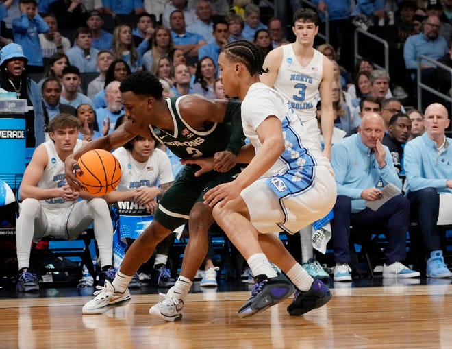 Michigan State Spartans guard Jaden Akins (3) controls the ball against North Carolina Tar Heels guard Seth Trimble (7) in the second round of the 2024 NCAA Tournament on Saturday at the Spectrum Center in Charlotte, N.C.