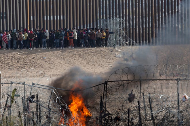 March 21, 2024 : Hundreds migrants line up on the border wall after they breached barriers set up by the Texas National Guard on the Rio Grande in El Paso, Texas. The migrants were hoping to be processed by Border Patrol.