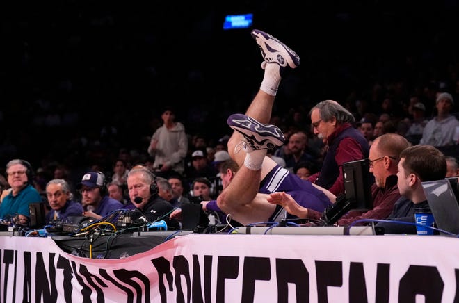 March 22, 2024 : Northwestern Wildcats guard Brooks Barnhizer dives into the scorer's table against the Florida Atlantic Owls in the first round of the 2024 NCAA Tournament at the Barclays Center.