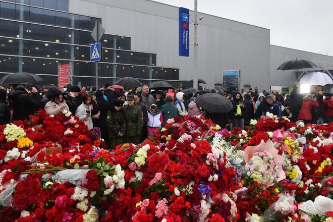 March 24, 2024 : People lay flowers at a makeshift memorial in front of the Crocus City Hall in Krasnogorsk as Russia observes a national day of mourning after a massacre that killed more than 130 people.